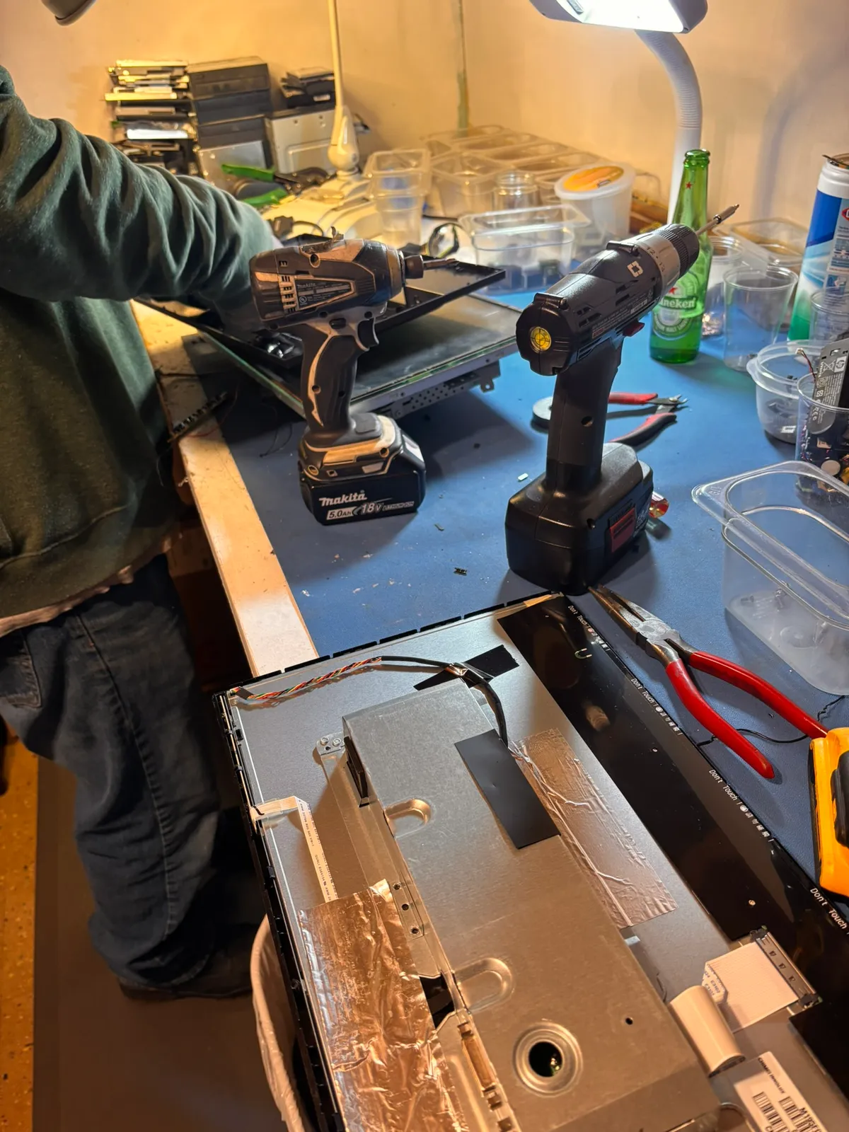 A laptop's screen assembly and logic board taken apart on the workbench