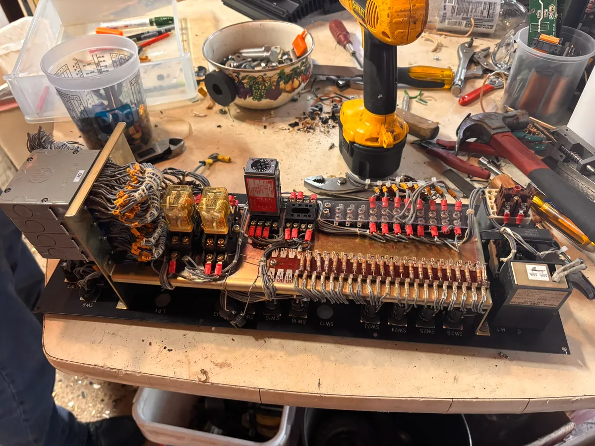 A row of relays, fuses, and terminal blocks pulled from an industrial control panel