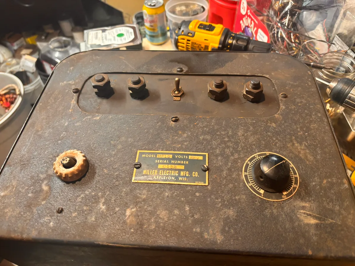 The control panel of a vintage Miller Electric welder, with its dial and toggle switch